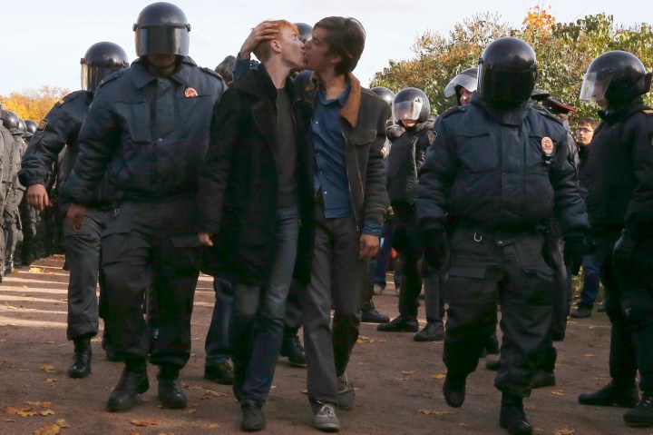 Gay rights activists kiss as they are detained by police officers during a gay rights protest in St. Petersburg