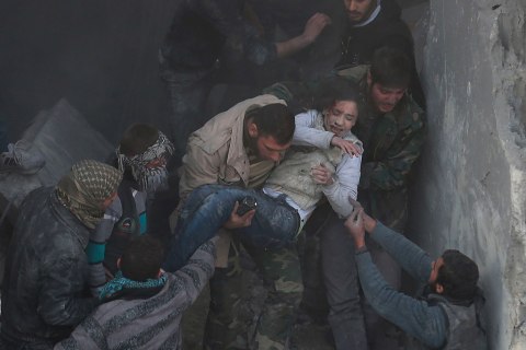 Men help a wounded girl who survived what activists say was an airstrike by forces loyal to Syrian President Bashar al-Assad in the Duma neighbourhood of Damascus