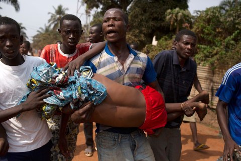 Men carry a boy, who died shortly after from a gunshot wound during a violent confrontation between Muslims and Christians, in Miskine district in Bangui
