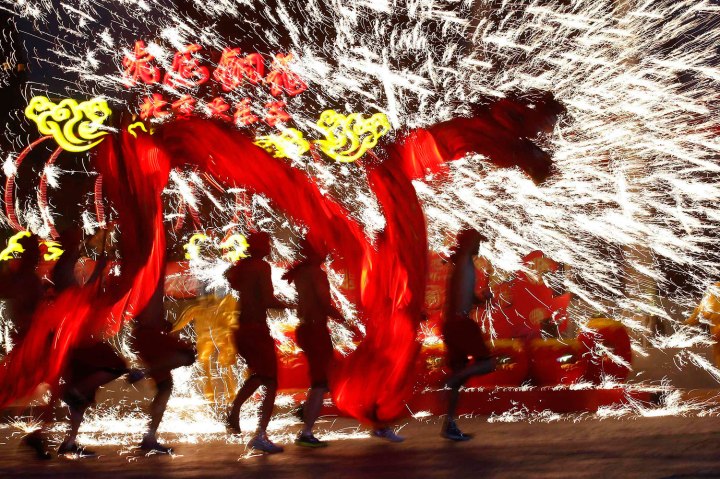 Dancers perform a fire dragon dance in the shower of molten iron spewing firework-like sparks during a folk art performance in Beijing