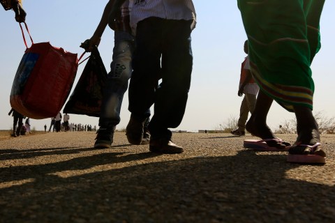 South Sudanese refugees walk at a border gate in Joda