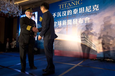 Actor Bernard Hill shakes hands with Su Shaojun, CEO of Seven-Star Energy Investment Group, during a news conference in Hong Kong