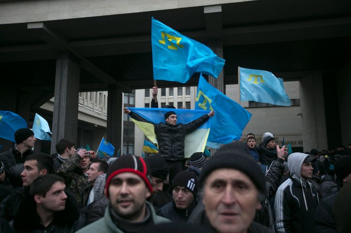 Crimean Tatars hold flags during rallies near the Crimean parliament building in Simferopol