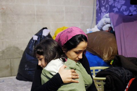 Shams consoles her daughter as they sit in a tent at the Church of Saint John the Baptist at the Beguinage in central Brussels