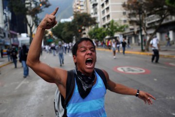 A demonstrator shouts slogans against Bolivarian National Guards during clashes in Caracas, March 2, 2014.