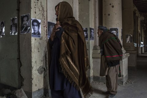 Afghan men look at photographs of people killed in the last three decades of conflict in the country at an exhibition in the ruins of the Darul Aman palace in Kabul, Afghanistan.