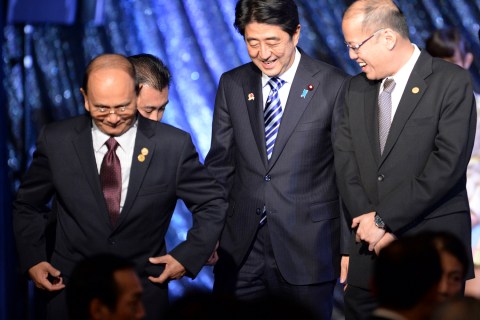 Japan's Prime Minister Shinzo Abe smiles with Myanmar's President Thein Sein and Philippine President Benigno Aquino as they leave the stage during a gala dinner of the ASEAN-Japan Commemorative Summit meeting in Tokyo