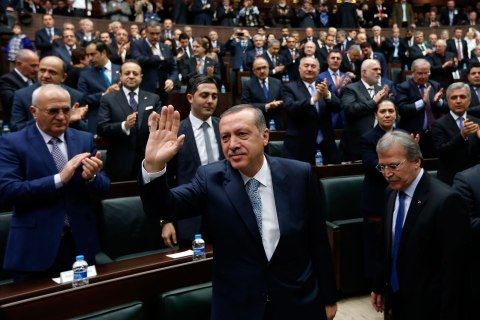 Turkey's Prime Minister Tayyip Erdogan greets his supporters as he arrives at a meeting at the Turkish parliament in Ankara