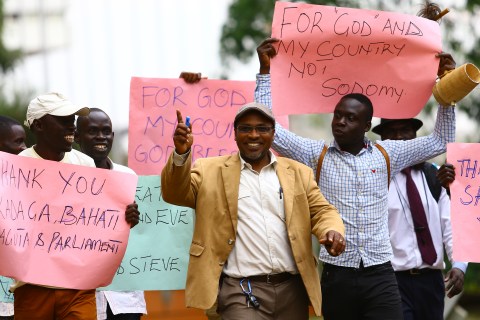 Ugandan anti-gay activist Pastor Ssempa leads anti-gay supporters as they celebrate after Uganda's President Museveni signed a law imposing harsh penalties for homosexuality in Kampala