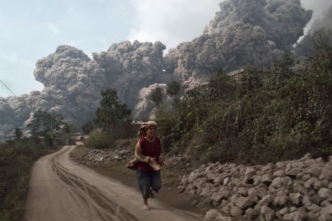 A villager run as Mount Sinabung erupt at Sigarang-Garang village in Karo district, Indonesia's North Sumatra province, Feb. 1, 2014. 
