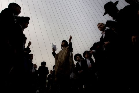 Ultra-Orthodox Jewish men pray during a rally attended by hundreds of thousands against plans to force them to serve in the Israeli military, blocking roads and paralyzing the city of Jerusalem, March 2, 2014. 