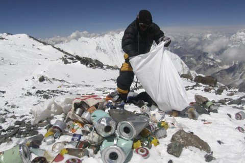 A Nepalese sherpa collects garbage left by climbers at an altitude of 8,000 metres during the Everest clean-up expedition at Mount Everest, on May 23, 2010.